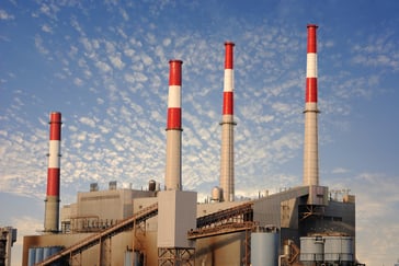 Factory against blue cloudy sky