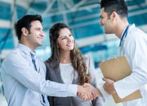 Family doctor handshaking a couple at the hospital